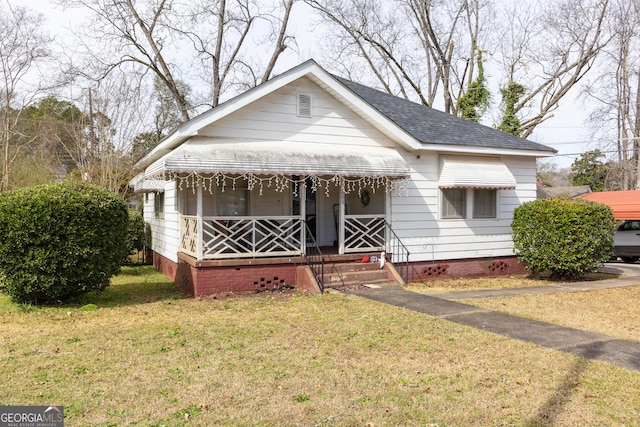 bungalow-style home with covered porch and a front yard