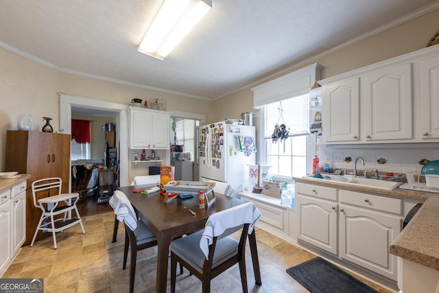 dining room featuring sink and crown molding