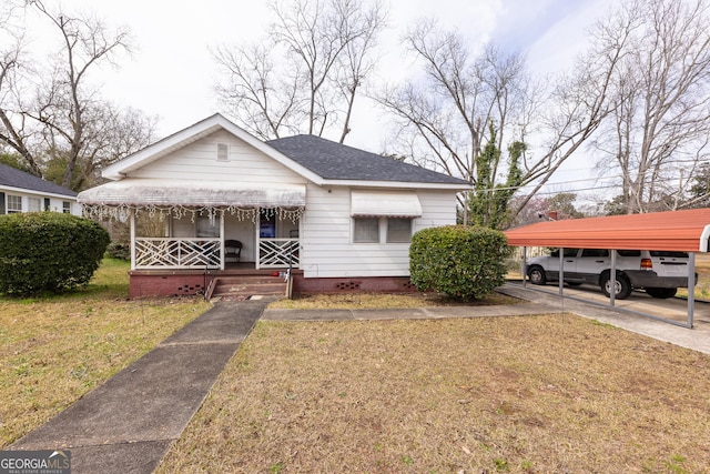 bungalow-style house with a front yard, a carport, and a porch