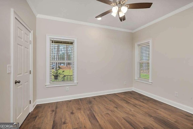 empty room featuring ceiling fan, baseboards, dark wood finished floors, and ornamental molding