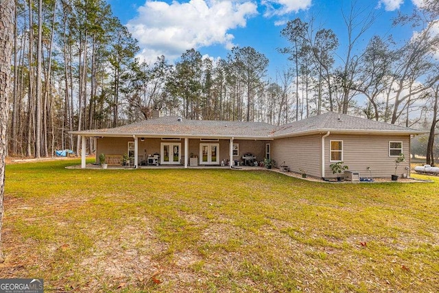 back of property featuring a patio, a chimney, a lawn, and french doors