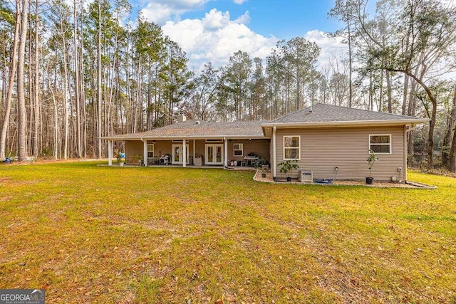 rear view of house featuring a yard