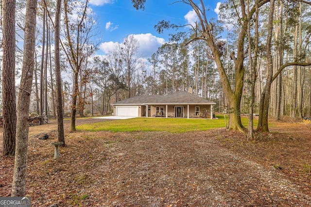 single story home featuring a garage, a front yard, covered porch, and driveway