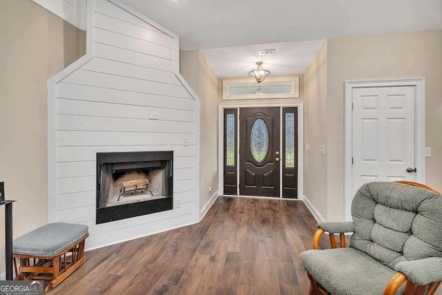 entrance foyer featuring a fireplace, baseboards, and wood finished floors