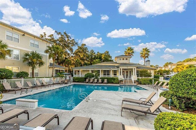 1704 Frederica Rd Unit 325, Saint Simons, GA 31522 - community pool featuring a patio, an outdoor structure, an exterior structure, and french doors