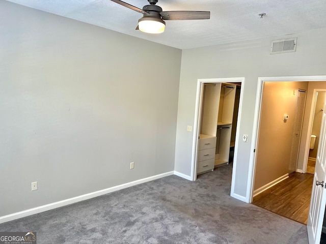 1704 Frederica Rd Unit 325, Saint Simons, GA 31522 - unfurnished bedroom featuring dark colored carpet, a walk in closet, a closet, and a ceiling fan
