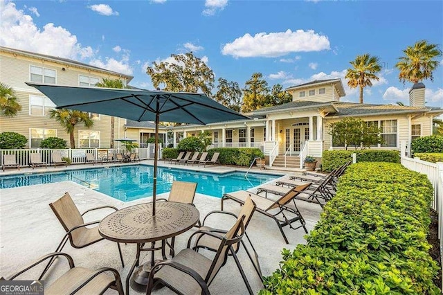 view of swimming pool with a patio area and french doors