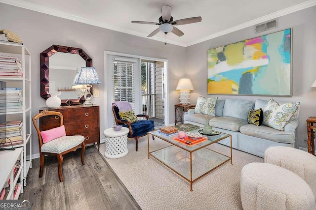 living room featuring crown molding, wood-type flooring, and ceiling fan