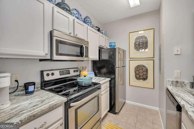 kitchen with white cabinetry, light tile patterned floors, light stone countertops, and appliances with stainless steel finishes