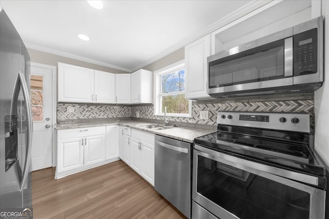 kitchen featuring crown molding, stainless steel appliances, sink, and white cabinets