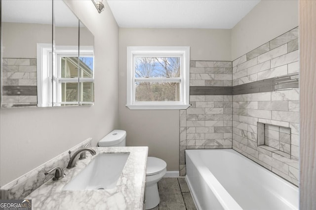 bathroom featuring vanity, toilet, and a bathing tub