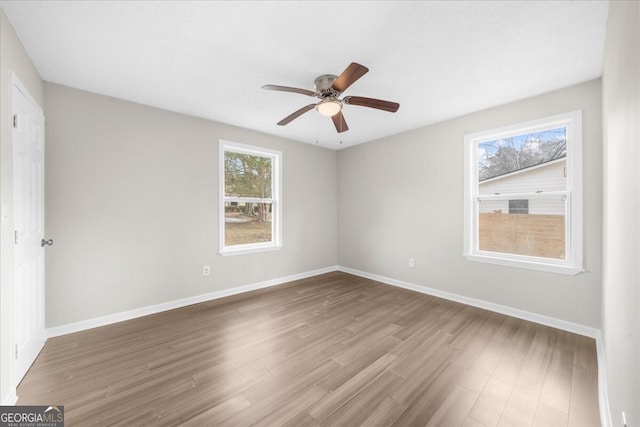 spare room with hardwood / wood-style floors and ceiling fan