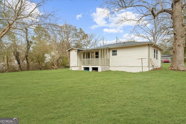 rear view of property featuring a yard and a porch