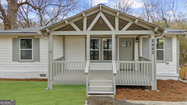 doorway to property featuring a yard and covered porch