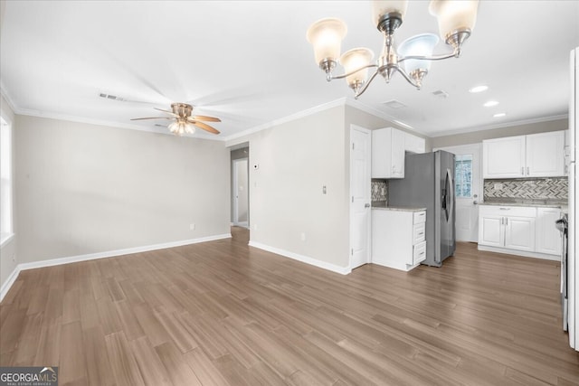 kitchen featuring tasteful backsplash, wood-type flooring, white cabinets, ornamental molding, and stainless steel fridge with ice dispenser