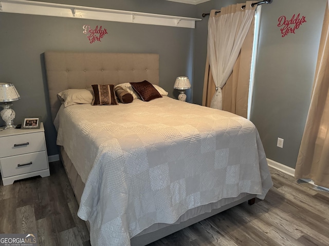 bedroom featuring baseboards and wood finished floors