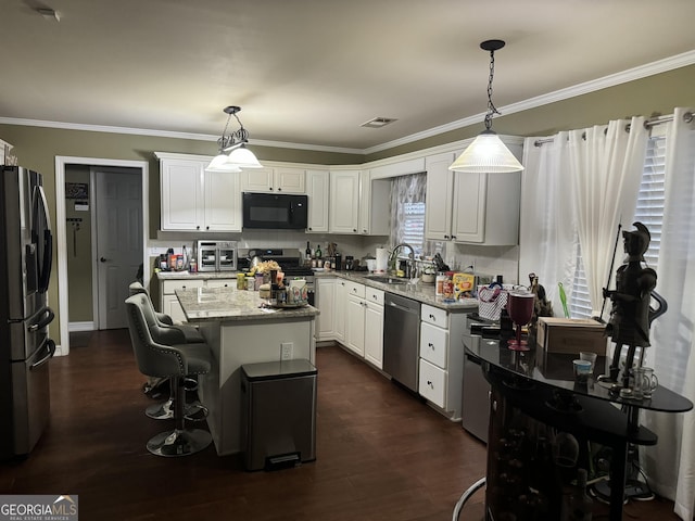 kitchen with a sink, white cabinetry, appliances with stainless steel finishes, and ornamental molding
