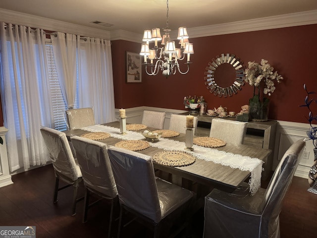 dining area with an inviting chandelier, wainscoting, dark wood-type flooring, and visible vents