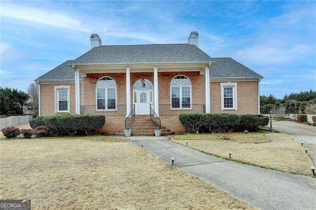 view of front facade featuring a front yard and covered porch