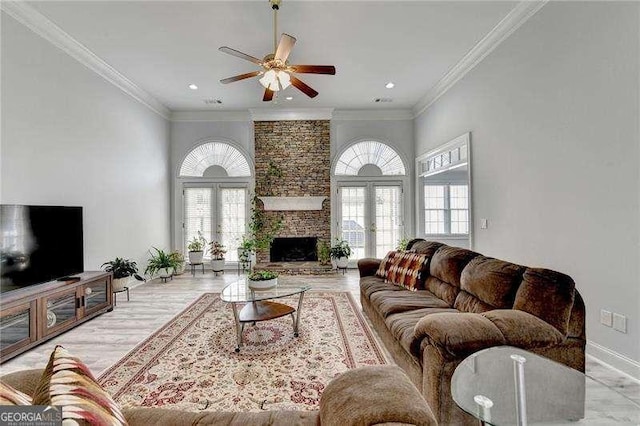 living room with crown molding, a stone fireplace, french doors, and ceiling fan