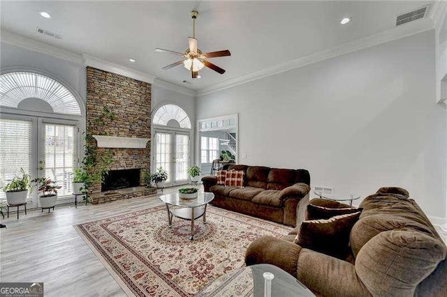 living room featuring plenty of natural light, a fireplace, and french doors