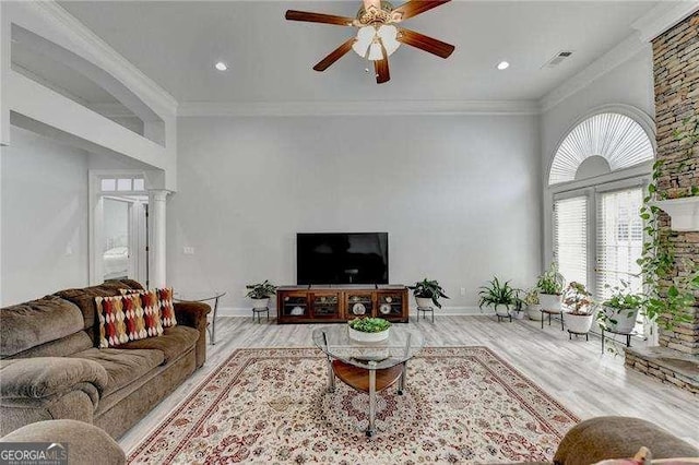 living room featuring decorative columns, crown molding, ceiling fan, and light hardwood / wood-style flooring