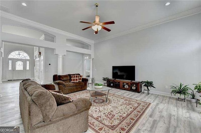 living room featuring ceiling fan, ornamental molding, and light wood-type flooring