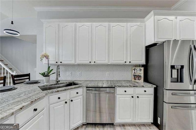 kitchen with white cabinetry, appliances with stainless steel finishes, light stone countertops, and sink