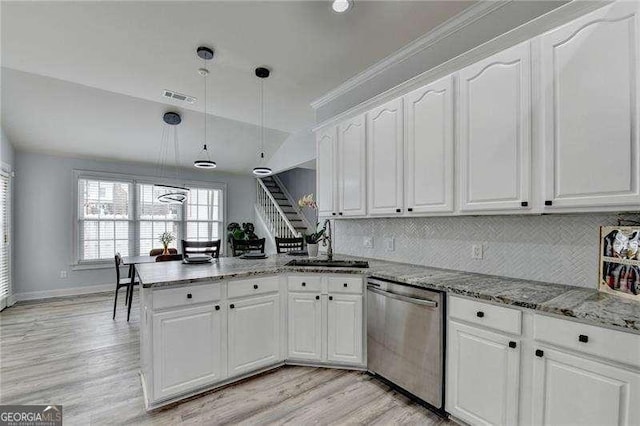 kitchen featuring pendant lighting, white cabinetry, sink, stainless steel dishwasher, and kitchen peninsula