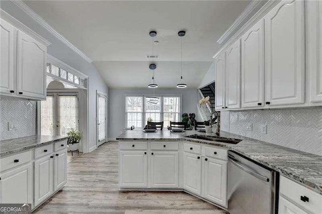 kitchen featuring pendant lighting, sink, white cabinets, and dishwasher