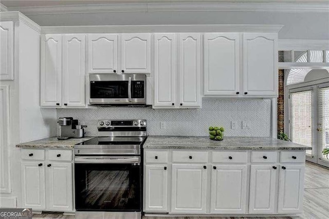 kitchen featuring white cabinetry, appliances with stainless steel finishes, backsplash, and light stone counters