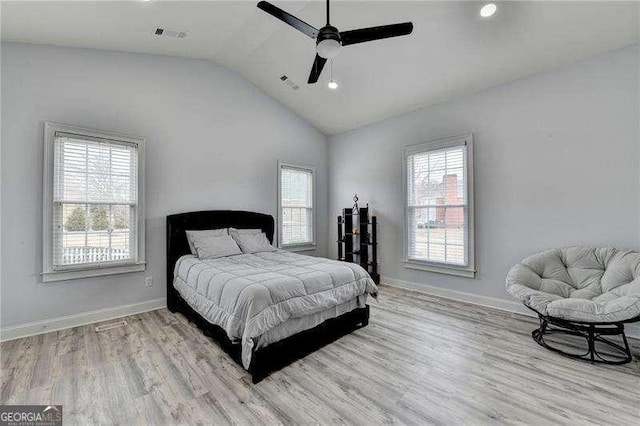 bedroom featuring lofted ceiling, multiple windows, and light wood-type flooring