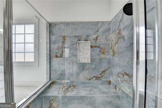 bathroom featuring a wealth of natural light and a tile shower