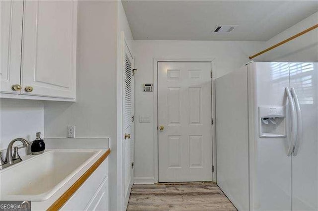 clothes washing area featuring light hardwood / wood-style floors and sink