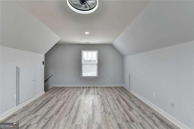 bonus room with lofted ceiling and light hardwood / wood-style floors