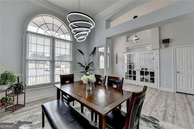 dining area featuring crown molding, hardwood / wood-style floors, french doors, and a notable chandelier