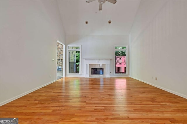 unfurnished living room with a high end fireplace, light hardwood / wood-style flooring, and plenty of natural light