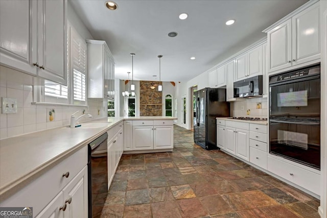 kitchen with sink, black appliances, white cabinets, decorative light fixtures, and kitchen peninsula