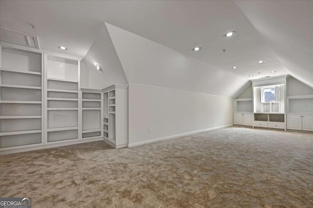 bonus room featuring lofted ceiling, carpet floors, and built in features