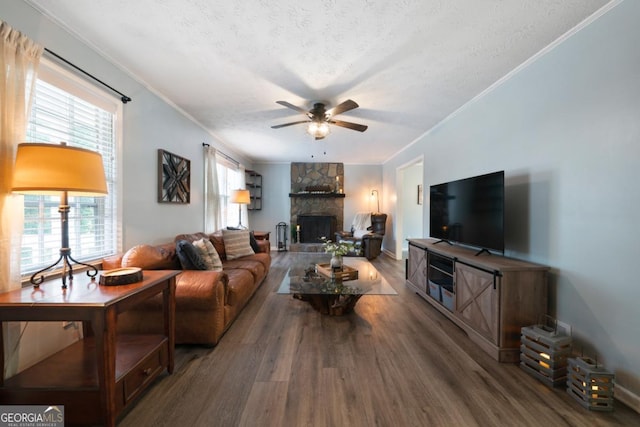 living room featuring ornamental molding, dark hardwood / wood-style floors, a textured ceiling, and ceiling fan