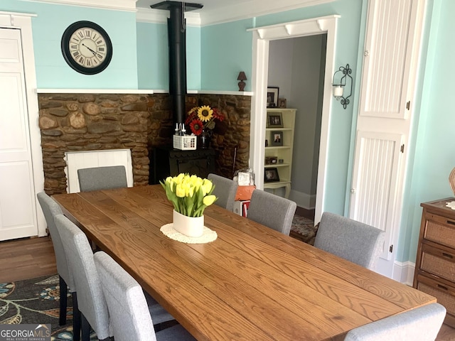 dining room with a wood stove and dark wood-type flooring