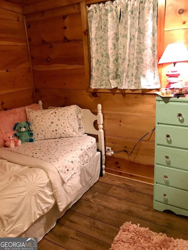 unfurnished bedroom featuring dark wood-type flooring and wood walls