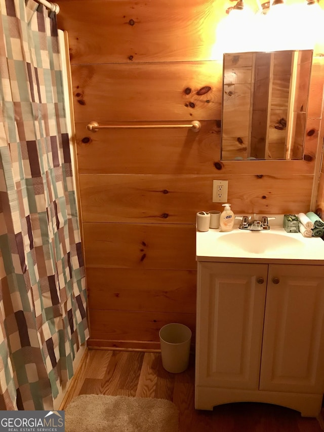 bathroom with vanity, wood-type flooring, and wood walls