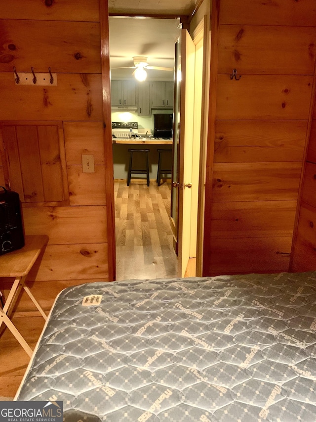 hallway with hardwood / wood-style floors and wooden walls