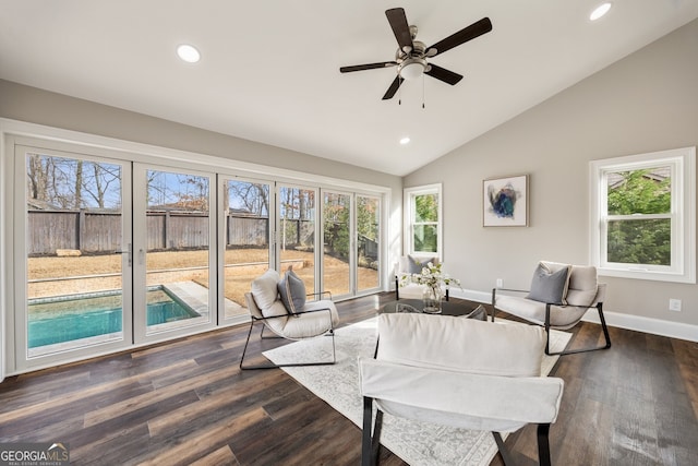 living room with ceiling fan, lofted ceiling, plenty of natural light, and dark hardwood / wood-style flooring