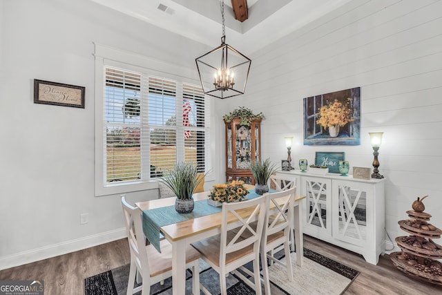 dining space featuring hardwood / wood-style flooring and a chandelier