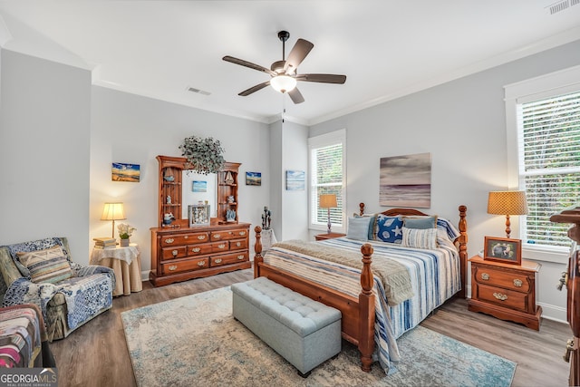 bedroom with hardwood / wood-style flooring, crown molding, and ceiling fan