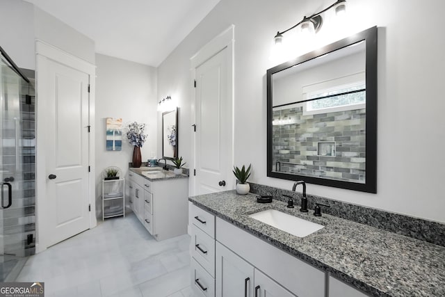 bathroom featuring a shower with door and vanity