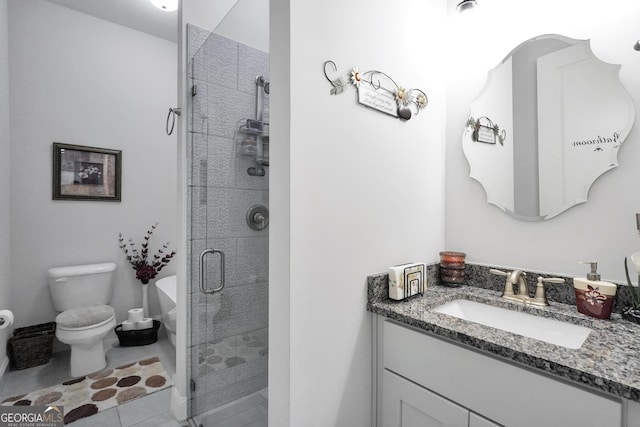 bathroom with vanity, a shower with shower door, tile patterned floors, and toilet