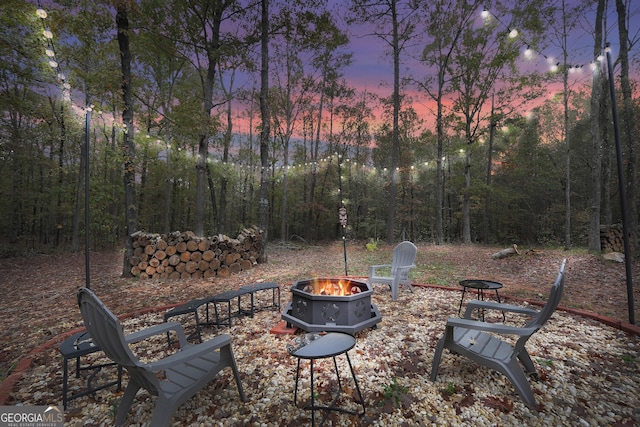 patio terrace at dusk featuring an outdoor fire pit